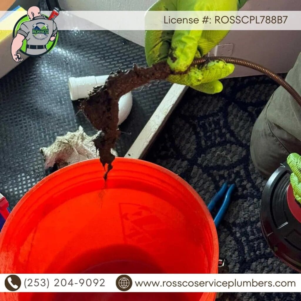 Plumber removing debris from drain